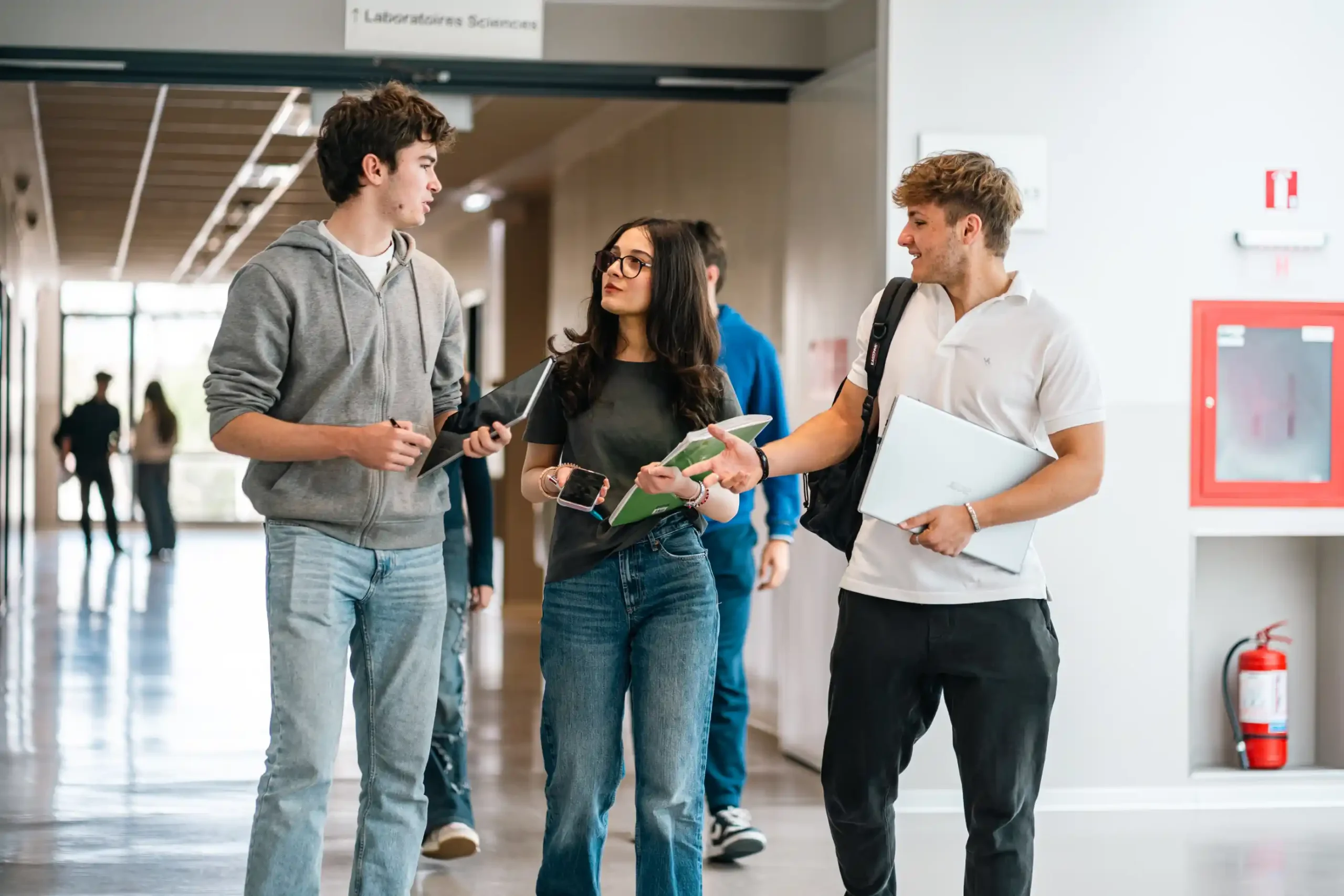 Des lycéens dans un couloir lumineux du campus
