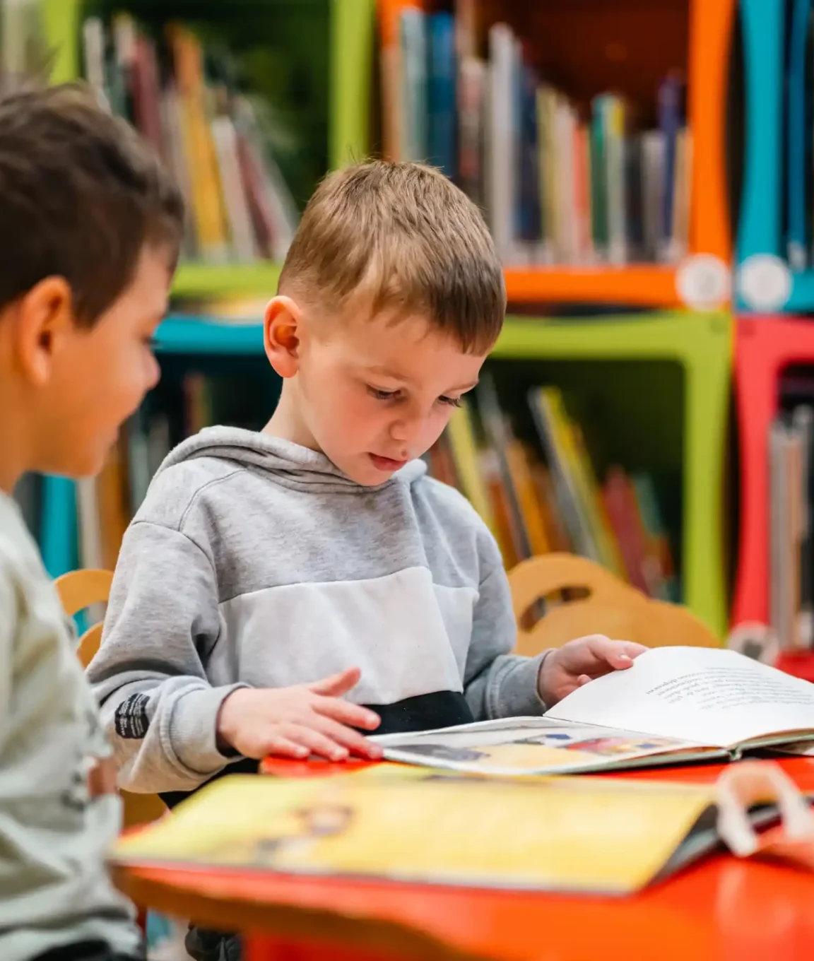 Deux élèves lisent ensemble à la bibliothèque de l'école
