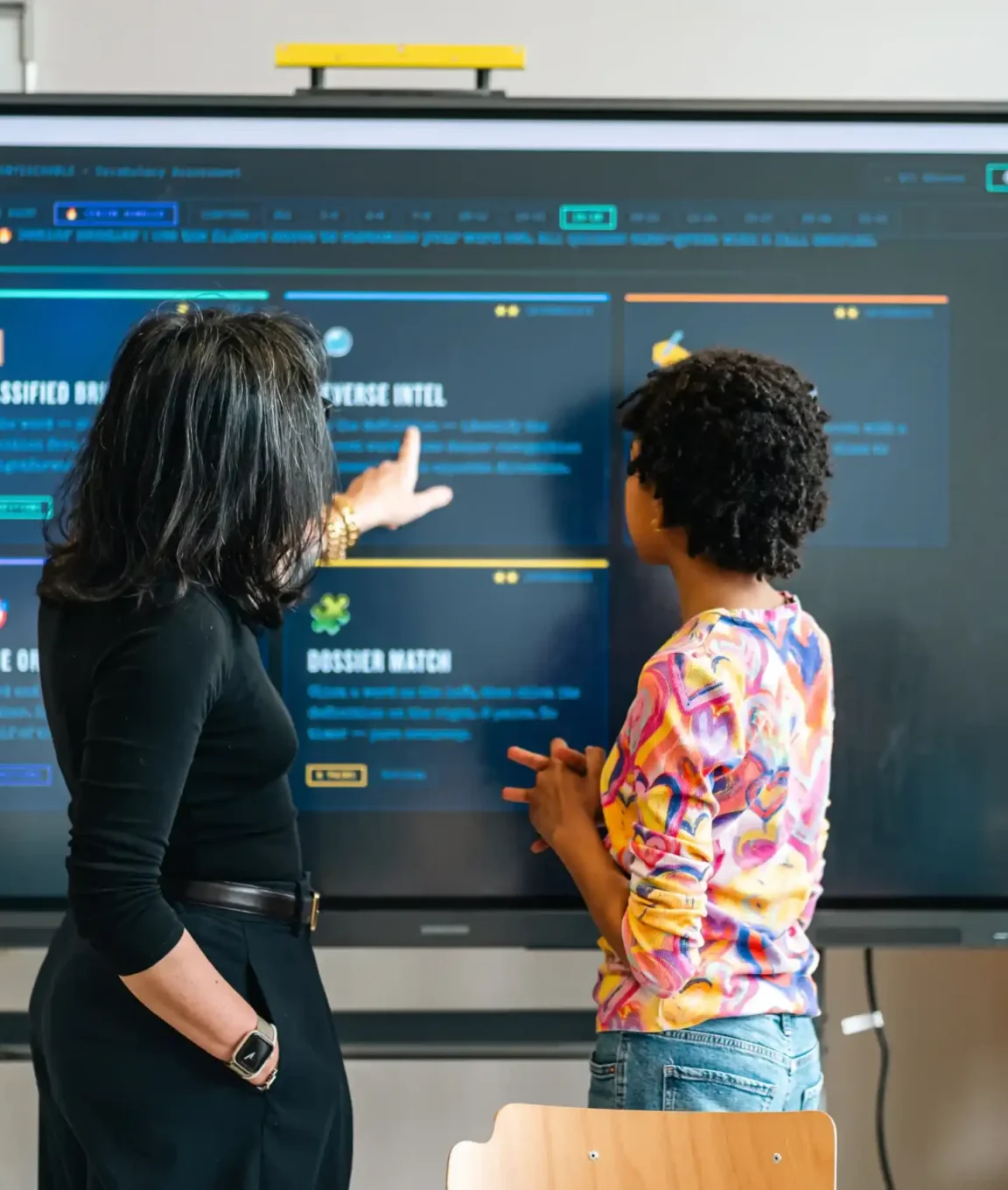 Deux élèves travaillent sur l'écran interactif de la classe