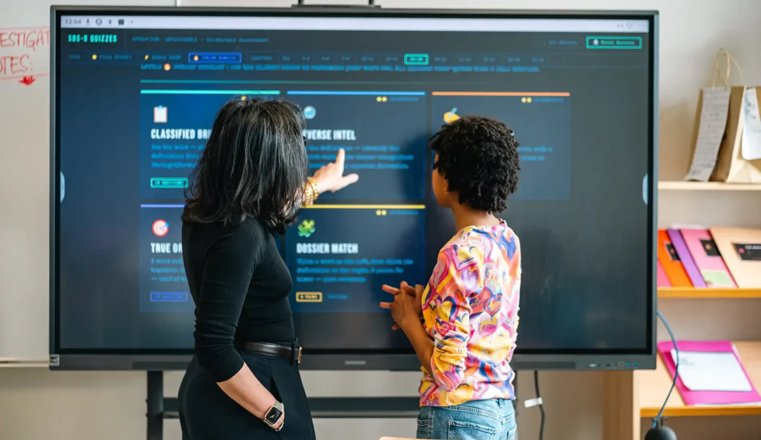 Deux élèves travaillent sur l'écran interactif de la classe