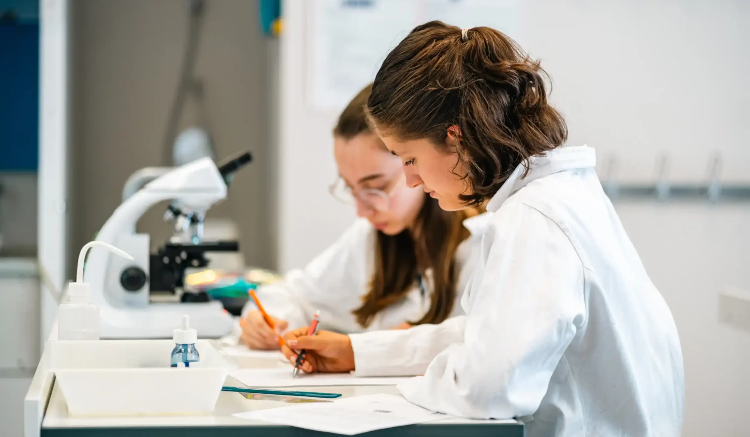 Une élève travaille au microscope en cours de sciences