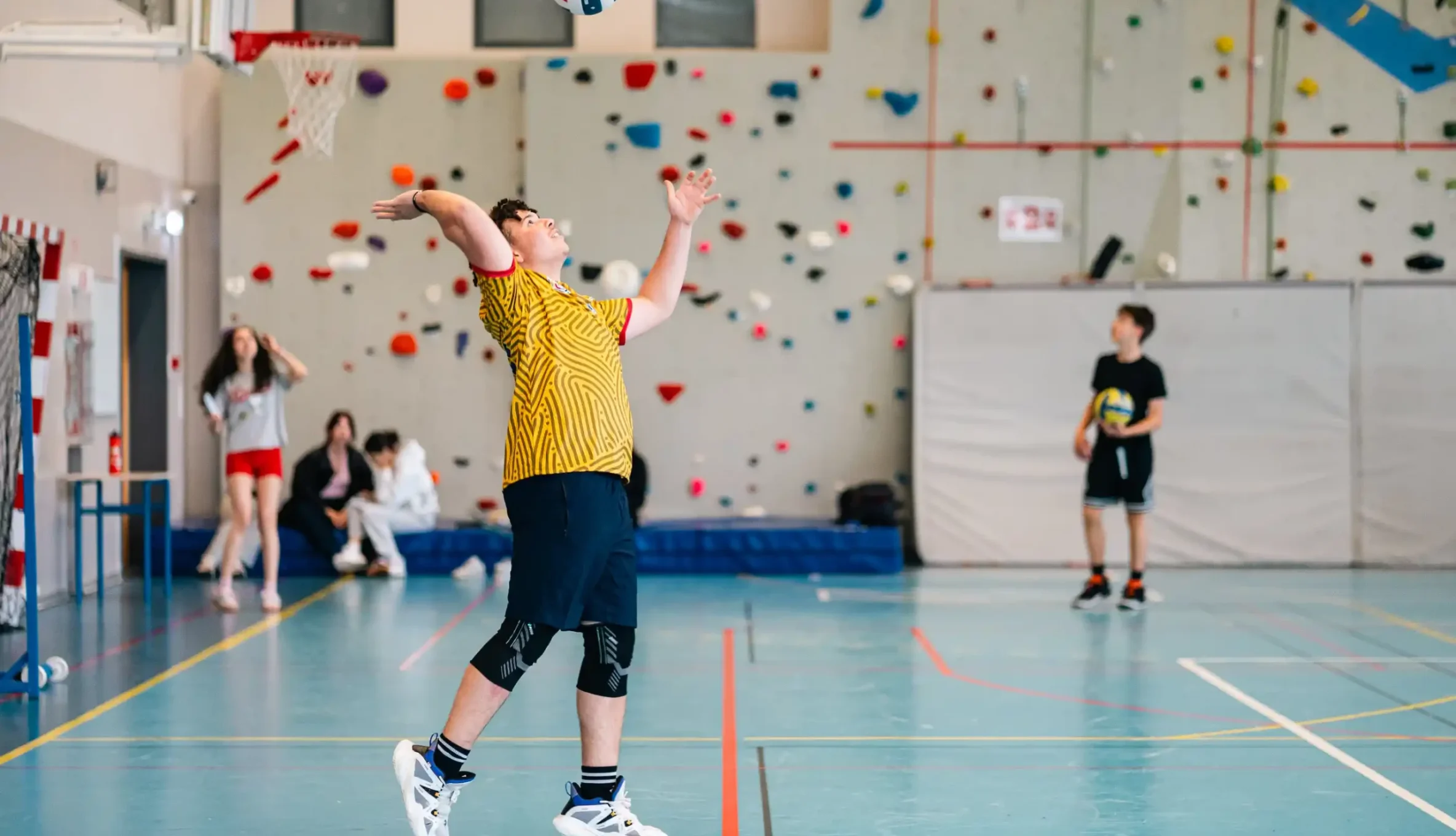 Service au volley-ball dans le gymnase