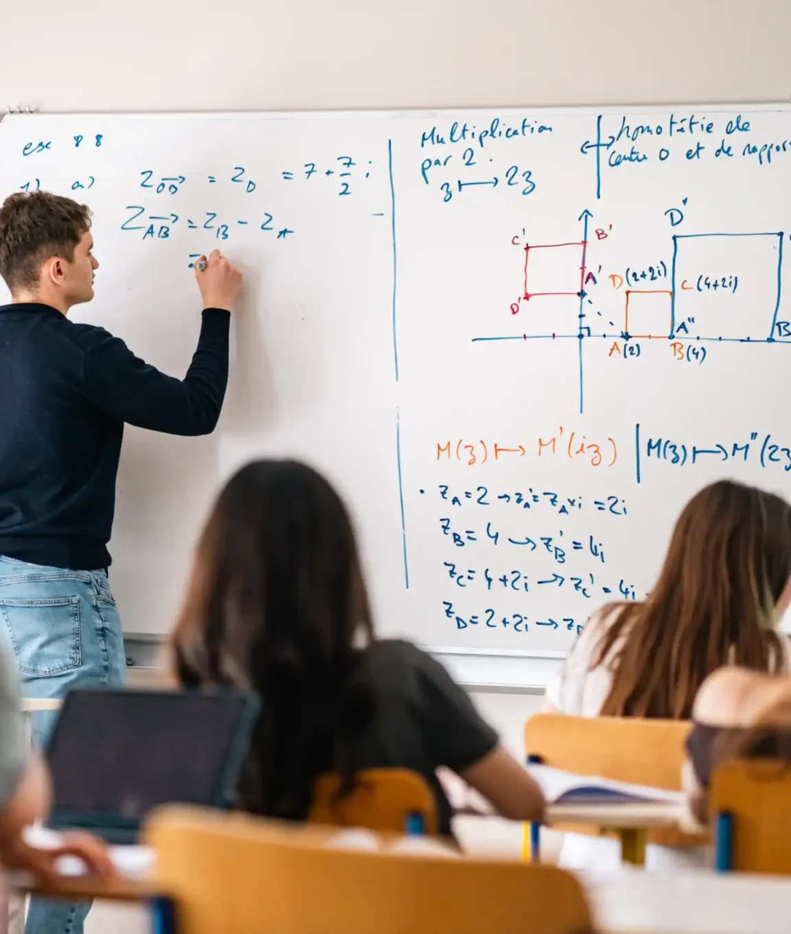 Un élève de lycée résout un exercice de mathématiques au tableau