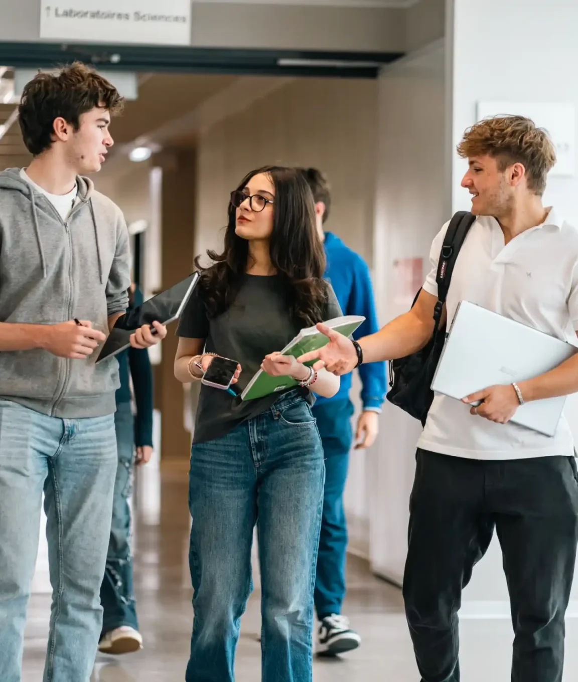 Des lycéens dans un couloir lumineux du campus